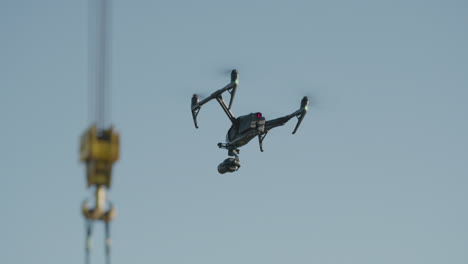 A-drone-with-a-camera-flies-near-a-crane