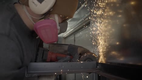 Closeup-of-blue-collar-worker-grinding-metal-with-angle-grinder,-slow-mo