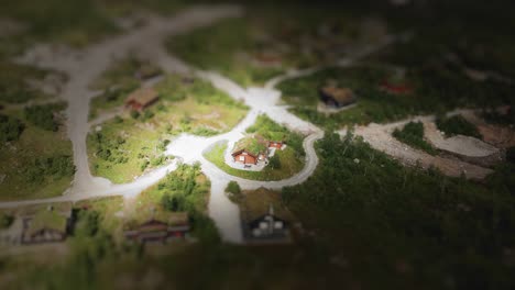 Made-using-tilt-shift-style-an-aerial-view-on-a-grass-roof-cabin-situated-in-a-tiny-Norwegian-village-located-on-green-Scandinavian-hills