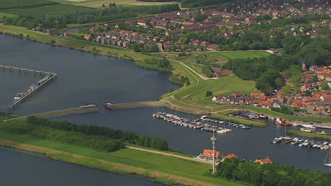 Smooth-flight-over-dutch-waterlands-in-summer-turning-around-a-little-village
