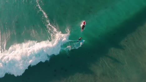 Aerial-Drone-Surfer-on-Wave-as-Surfer-Paddles-Out---Overhead