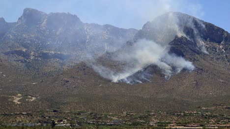 Helicopter-of-Firefighters-Department-Flying-Above-Wildfire-Smoke-on-Hillside-of-Santa-Catalina-Mountains,-North-of-Tucson,-Arizona-USA