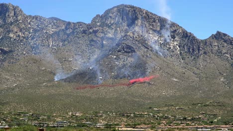 Aerial-Firefighting,-Aircraft-Dropping-Chemical-Retardant-Under-Wildfire-on-Hill-of-Santa-Catalina-Mountains,-Arizona-USA