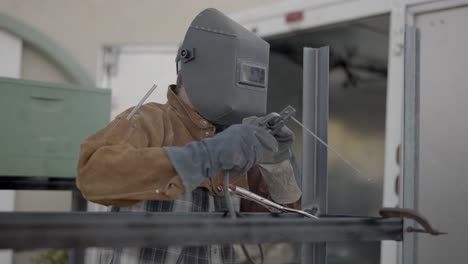 Welder-Using-Stick-Welder-Removes-Mask-To-Check-His-Work,-Slow-Motion