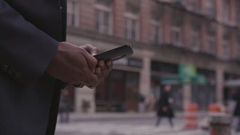 A-businessman-uses-a-phone-on-a-city-sidewalk