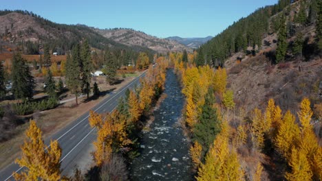 Río-Salvaje-Que-Fluye-Rápido-Por-La-Carretera-Cerca-De-Un-Pequeño-Pueblo-En-Washington,-EE.UU.