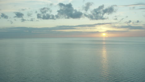 Sonnenuntergang-Im-Ruhigen-Meer-Mit-Einigen-Kleinen-Wolken