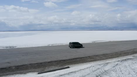 Car-on-Road-Trip-through-Bonneville-Salt-Flats-in-Utah---Aerial-Orbit