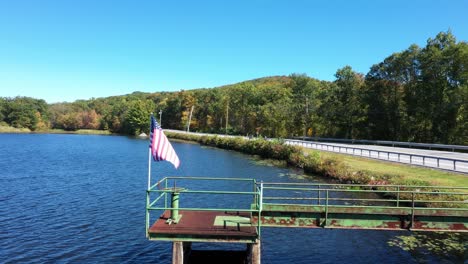 American-flag-waving-on-lakeshore-bridge-near-coastal-road