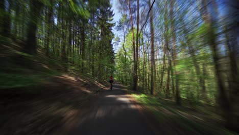 A-rear-view-of-the-female-cyclist-riding-a-bicycle-in-the-Divoka-Sarka-nature-reserve-in-Pague