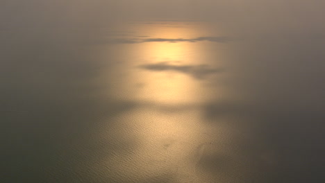 El-Sol-Poniente-Se-Refleja-En-El-Mar-Con-Algunos-Parches-De-Sombra-Proyectados-Por-Las-Nubes-Filmadas-Desde-Lo-Alto