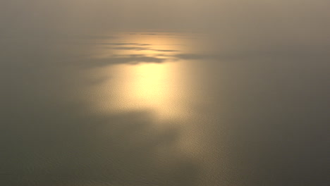 El-Sol-Poniente-Se-Refleja-En-El-Mar-Con-Algunos-Parches-De-Sombra-Proyectados-Por-Las-Nubes