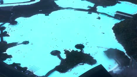 Luftaufnahme-Der-Blauen-Lagune-Mit-Winzigen-Bildern-Von-Menschen,-Die-Das-Geothermalbad-In-Der-Nähe-Von-Reykjavik,-Island,-Genießen