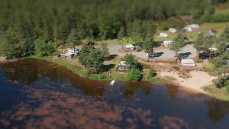 A-flight-above-a-Kilefjorden-camping-located-nearby-a-coniferous-forest-on-a-coastline-of-Otra-river