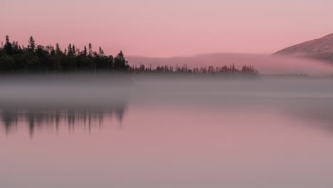 Rosafarbener-ätherischer-Nebel,-Der-über-Dem-Stillen-Wasser-Des-Sees-Schwebt