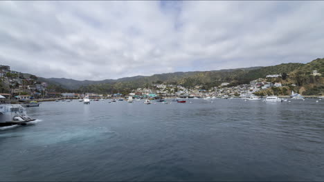 Timelapse-of-the-Ferry-arriving-and-boats-bobbing-in-the-harbor-with-clouds-passing-overhead-on-Catalina-Island-in-Southern-Californian-Pacific-Ocean