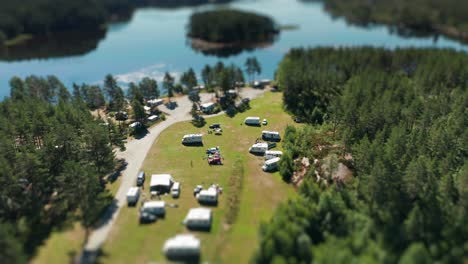 Tens-of-motorhomes,-minivans,-and-cars-parked-in-Kilefjorden-camping-are-seen-from-the-air-on-a-sunny-day