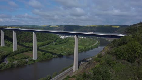 Aerial-trucking-shot-of-Moselle-Bridge-in-Winningen-during-sunny-day-with-traffic-in-Germany