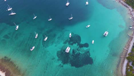 Boote-In-Einer-Bucht-Nahe-Der-Küstenstadt-Kroatiens-Vor-Dem-Hintergrund-Des-Blauen-Himmels-Und-Des-Blauen-Transparenten-Wassers-Und-Der-Häuser-Mit-Roten-Dächern