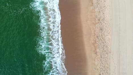 High-angle-aerial-view-of-clear-turquoise-sea-and-waves
