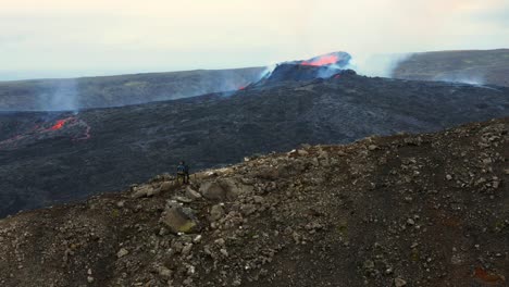 People-On-Mountain-Admiring-Scenic-View-Of-Erupting-Crater-Of-Fagradalsfjall-Volcano-In-Iceland