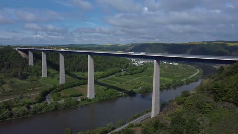 Aerial-drone-pan-shot-of-crossing-vehicles-on-Moselle-Bridge-during-summer-day-in-Germany