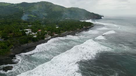 Aerial-view-moving-forward-shot,-scenic-view-of-the-bitcoin-beach-in-El-Salvador,-Mexico,-houses-and-trees-in-the-background