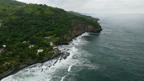 Aerial-view-moving-forward-shot,-scenic-view-of-the-coast-of-the-bitcoin-beach-in-El-Salvador,-Mexico,-rock-formation-in-the-background