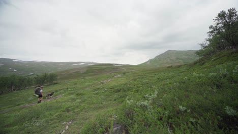 Hombre-Caminando-Con-Su-Perro-En-Trekanten-En-La-Montaña-Trollheimen,-Noruega
