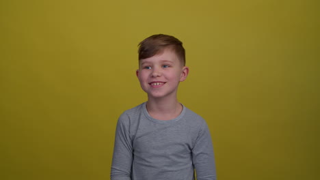 Boy-laughing-over-yellow-background