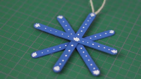 Blue-snowflake-made-of-popsicle-sticks-on-a-cutting-mat