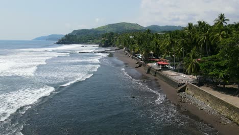 Aerial-view-moving-forward-shot,-scenic-view-coconut-trees-on-the-beach-of-the-bitcoin-beach-in-El-Salvador-Mexico,-sunny-day-in-the-background