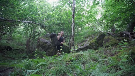 Caucasian-Hiker-Puts-On-Backpack-In-The-Forested-Mountain-Of-Katthammaren-In-Norway