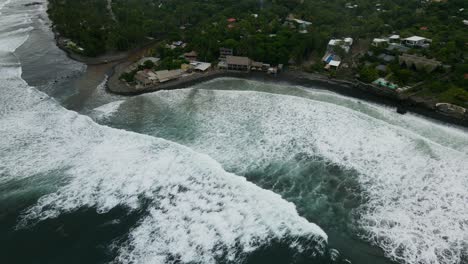 Bird’s-eye-view-descending-shot,-scenic-view-of-the-bitcoin-beach-in-El-Salvador,-Mexico,-ripples-of-waves-on-the-shore-in-the-background
