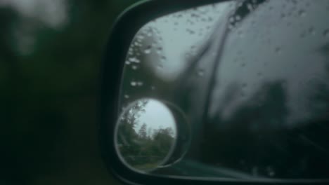 Reflection-in-mirror-dotted-with-raindrops-of-a-country-road-in-the-UK