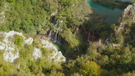 Unglaubliche-Drohnenansicht-Aus-Der-Luft-Auf-Leuchtend-Türkisfarbene-Seen,-Die-Mit-Wasserfällen-Zwischen-Felsigen-Klippen-Und-Dichtem-Wald-Verbunden-Sind