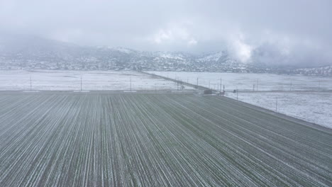 Flying-through-a-snowstorm-over-a-wintery,-snowy-farm-in-Tehachapi,-CA