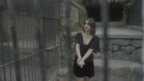 Slow-motion-clip-of-a-gothic-girl-model-behind-bars-in-a-jail-doing-a-pirouette