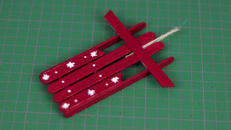 Red-snow-sled-made-with-popsicle-sticks-on-a-cutting-mat