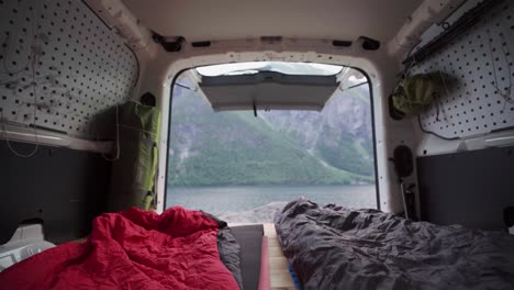 View-Of-Fjord-And-Rocky-Mountain-From-Bed-Inside-A-Camper-Van-In-Norway