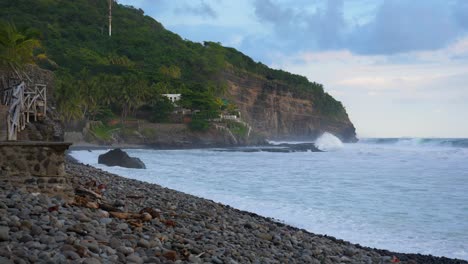 Full-shot,-waves-rushing-to-the-shoreline-on-the-bitcoin-beach-in-El-Salvador-mexico,-scenic-view-of-the-rocky-wall-of-cliff-in-the-background