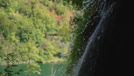Schöne-Zeitlupenaufnahme-Eines-Kleinen-Waldwasserfalls,-Der-über-Eine-Kaskade-Von-Felsen-Spritzt