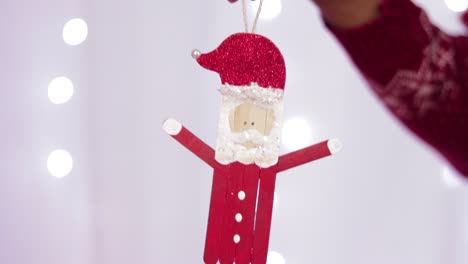Someone-holding-a-figure-of-santa-claus-made-with-popsicle-sticks