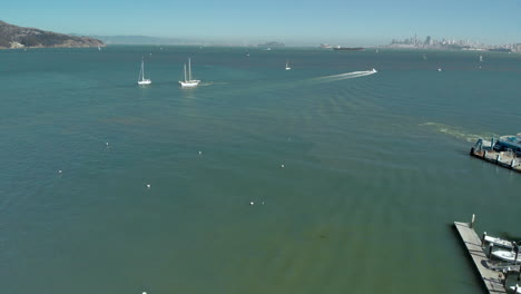 Flying-over-shorefront-of-Sausalito-Harbor-with-San-Francisco-in-the-background