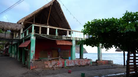 Volle-Aufnahme,-Malerischer-Blick-Auf-Ein-Strandhaus-Am-Strand-Des-Bitcoin-strandes-In-El-Salvador,-Mexiko,-Blauer-Himmel-Und-Wellen-Im-Hintergrund