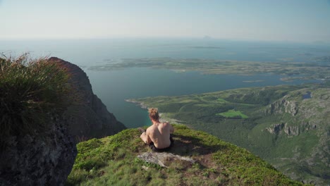Excursionista-Sin-Camisa-Sentado-Y-Tomando-Fotos-De-Donnmannen-En-Noruega