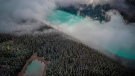 Time-Lapse-of-Clouds-Formations-Above-Aqua-Blue-Glacial-Water-and-Evergreen-Forest
