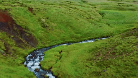 Drone-Flyover-Greenery-Landscape-With-Hveragerdi-Hot-Springs-River-In-Reykjadalur,-Iceland
