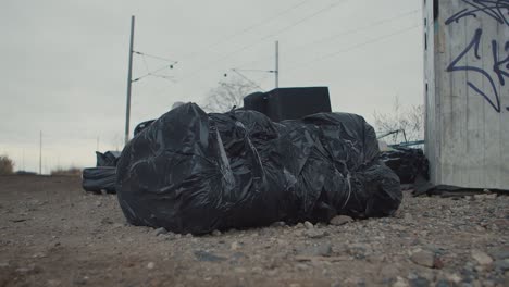 Illegale-Müllhalde-Draußen,-Schwarze-Plastiktüte-Mit-Müll-Oder-Leiche,-Tatort