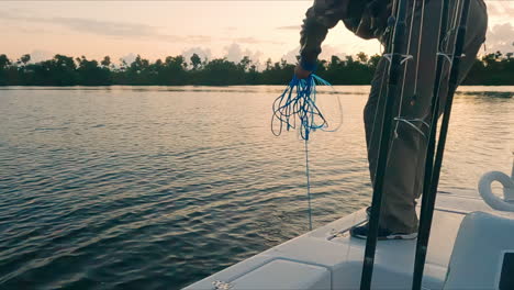 Handheld-shot-of-nest-fishing-fisherman-catching-fishes-on-boat,-sunset